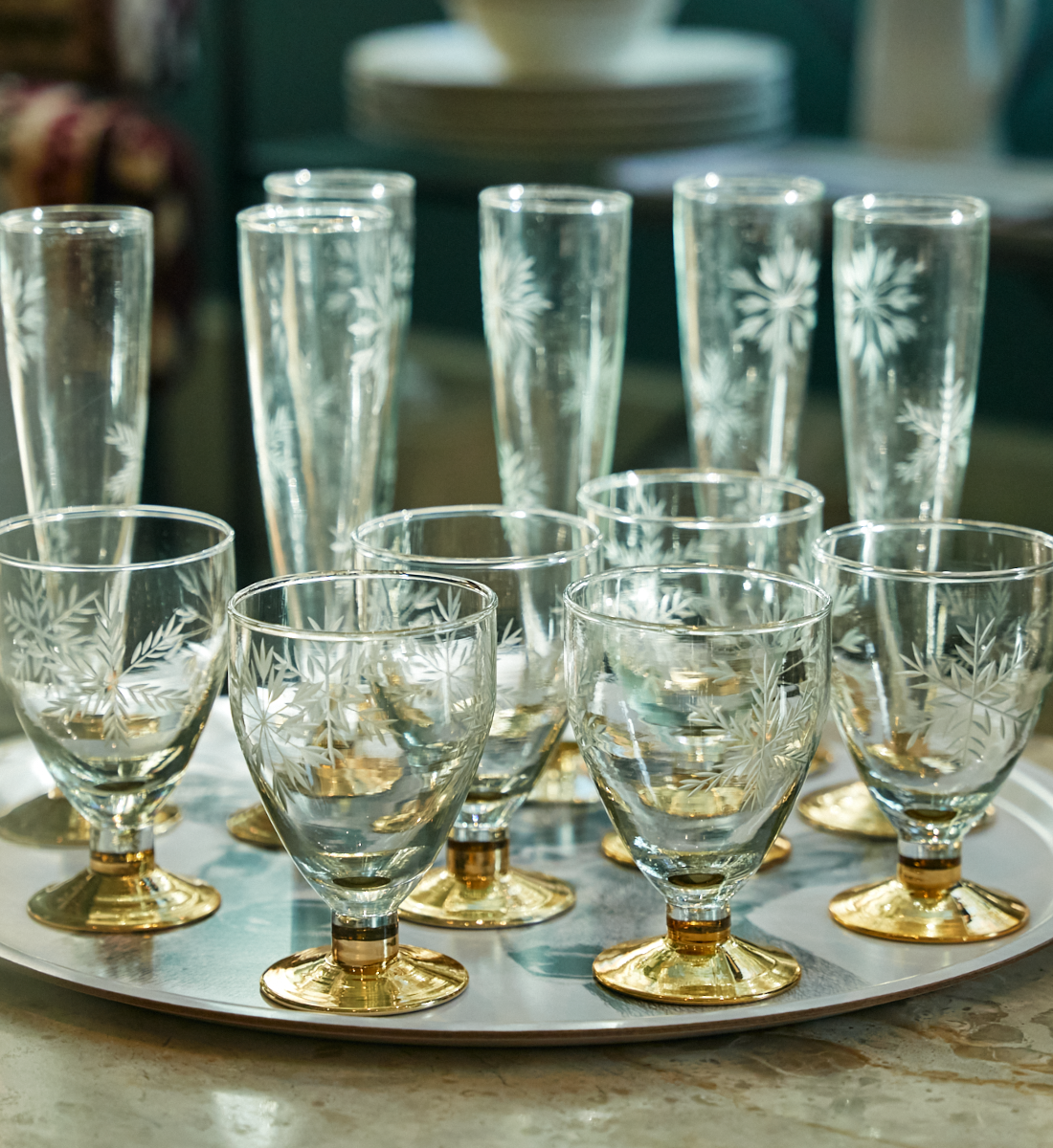 Vintage and artisan drinkware displayed at Maude Woods Pasadena, featuring etched glass goblets and stemware with gold-rimmed details for classic entertaining.